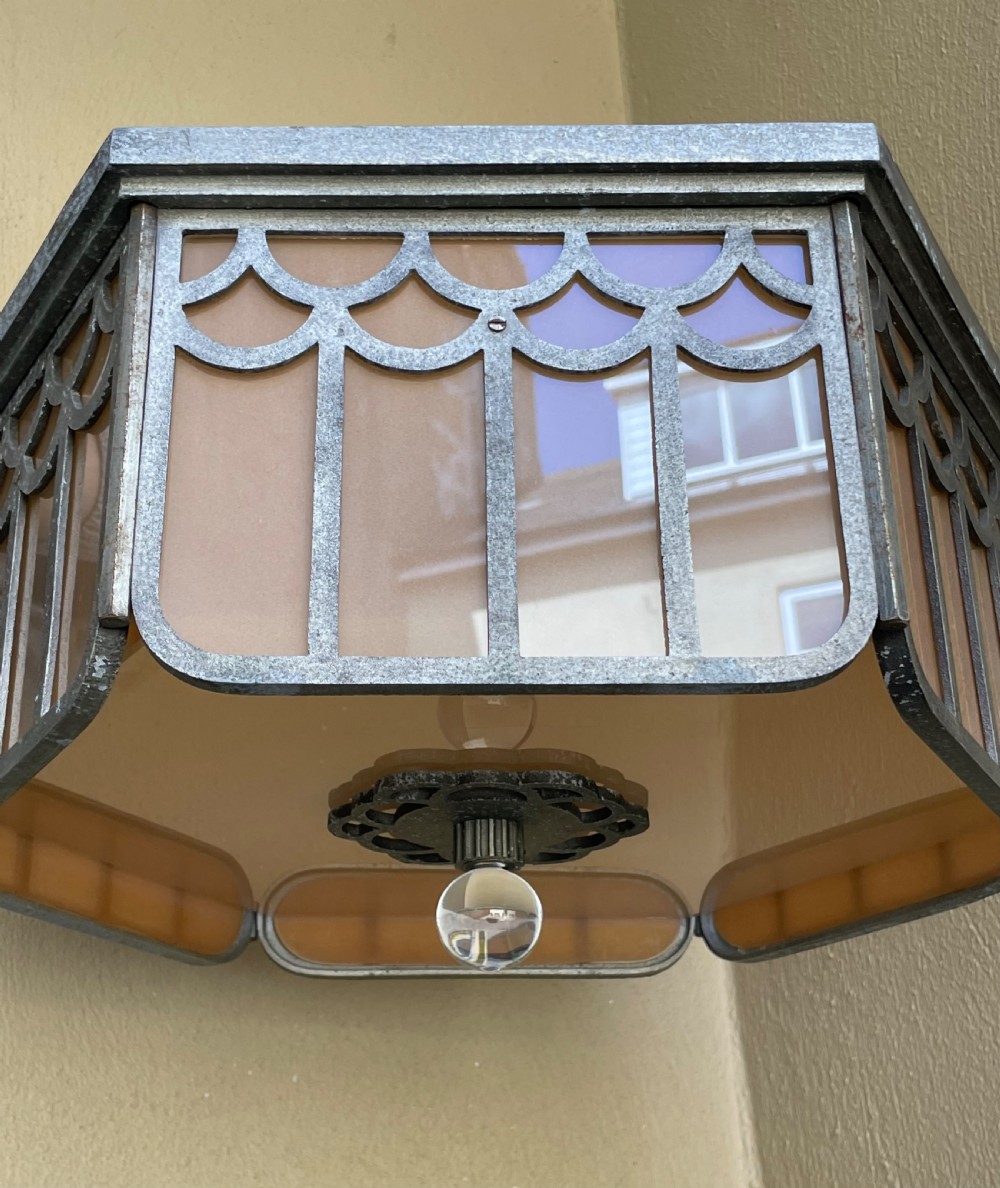 An Art Deco hexagonal flush ceiling light featuring frosted amber glass panels set within a scalloped metal frame and a central glass finial. View VII