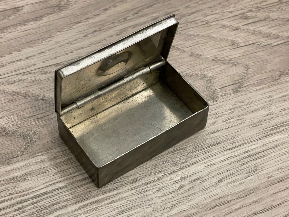 A rectangular 19th-century pewter snuff box featuring a flat hinged lid with a central recessed ring pull handle. View IV