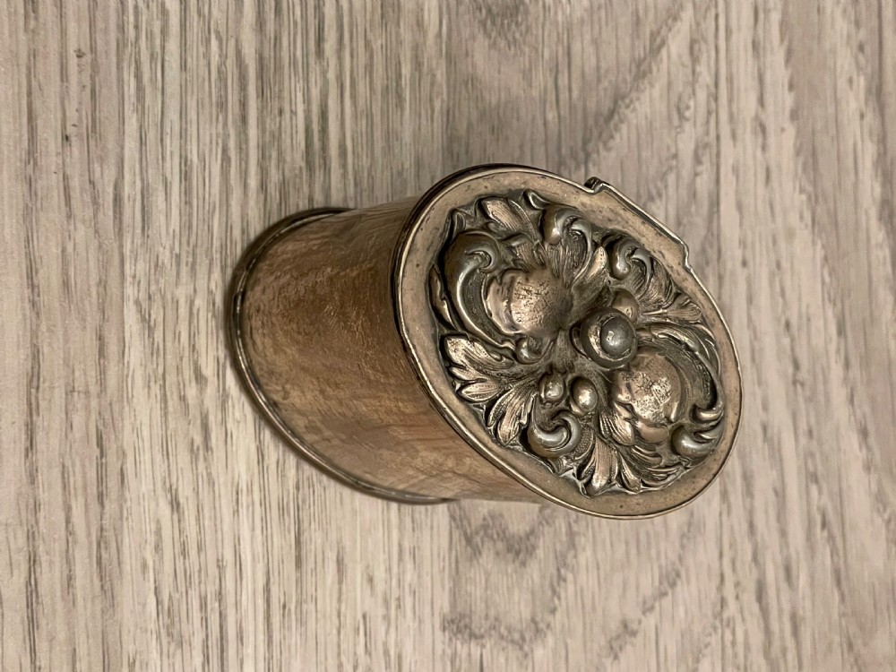 A cylindrical silver plated tea caddy featuring a repousse foliate patterned lid with a raised central finial. View VI