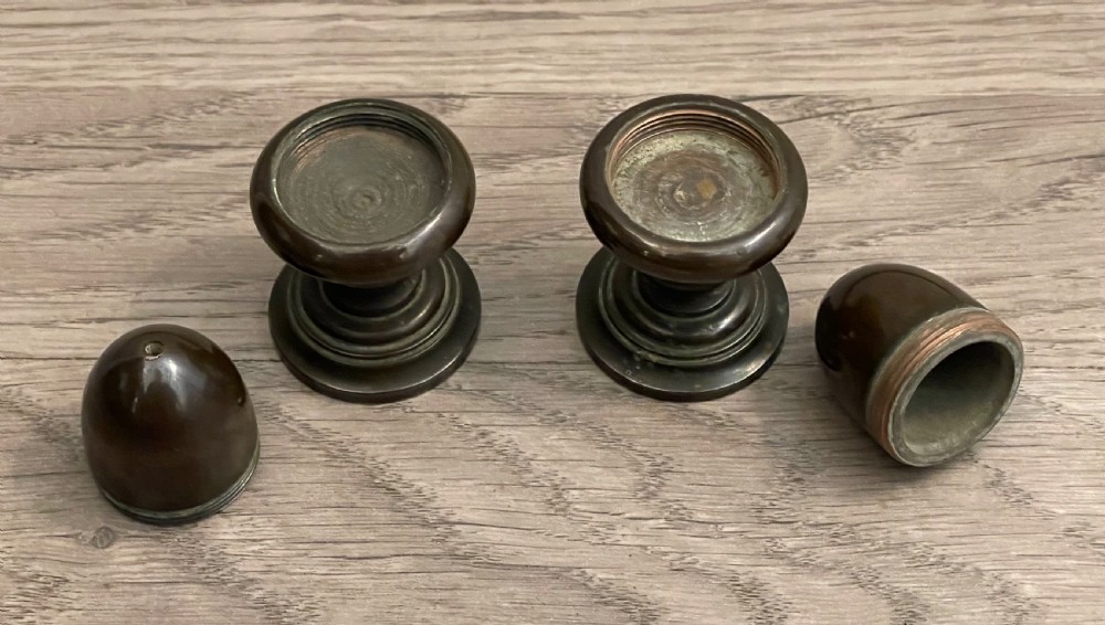 A pair of turned dark bronze spice shakers featuring acorn-form tops set upon circular stepped pedestal bases. View III