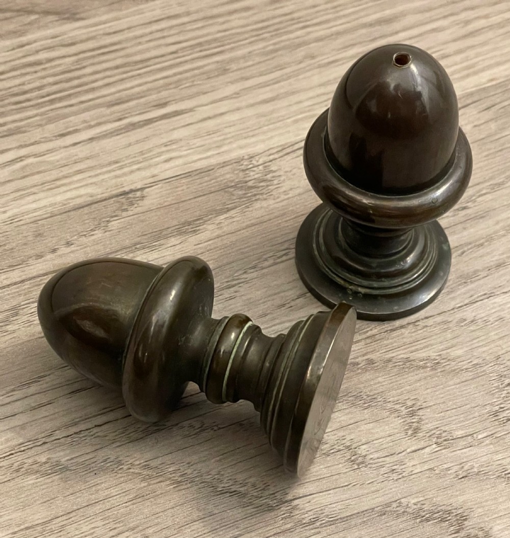 A pair of turned dark bronze spice shakers featuring acorn-form tops set upon circular stepped pedestal bases. View IV