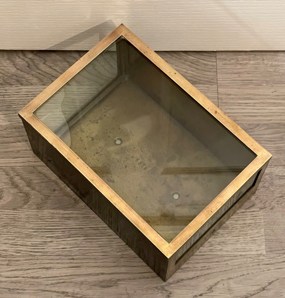 A rectangular patinated brass display case featuring a clear glass top, glazed front panel, and lower brass section with a built-in keyhole. View II
