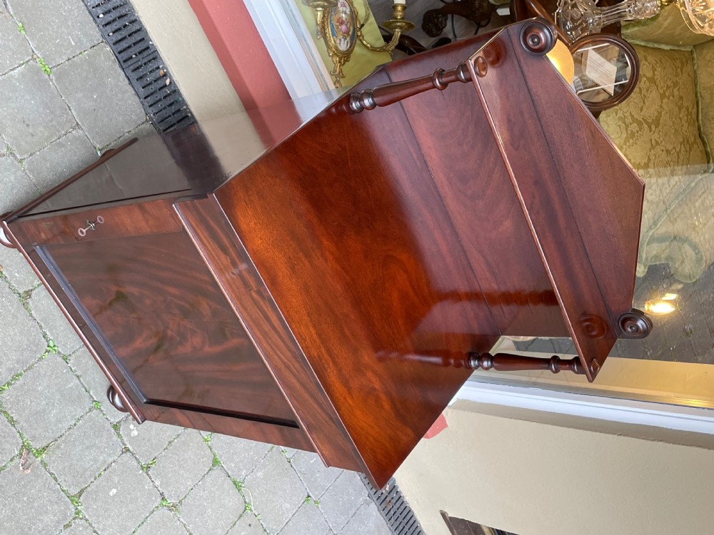 An early Victorian mahogany chiffonier sideboard featuring a top shelf with turned supports, a single frieze drawer, and a paneled cupboard door. View V