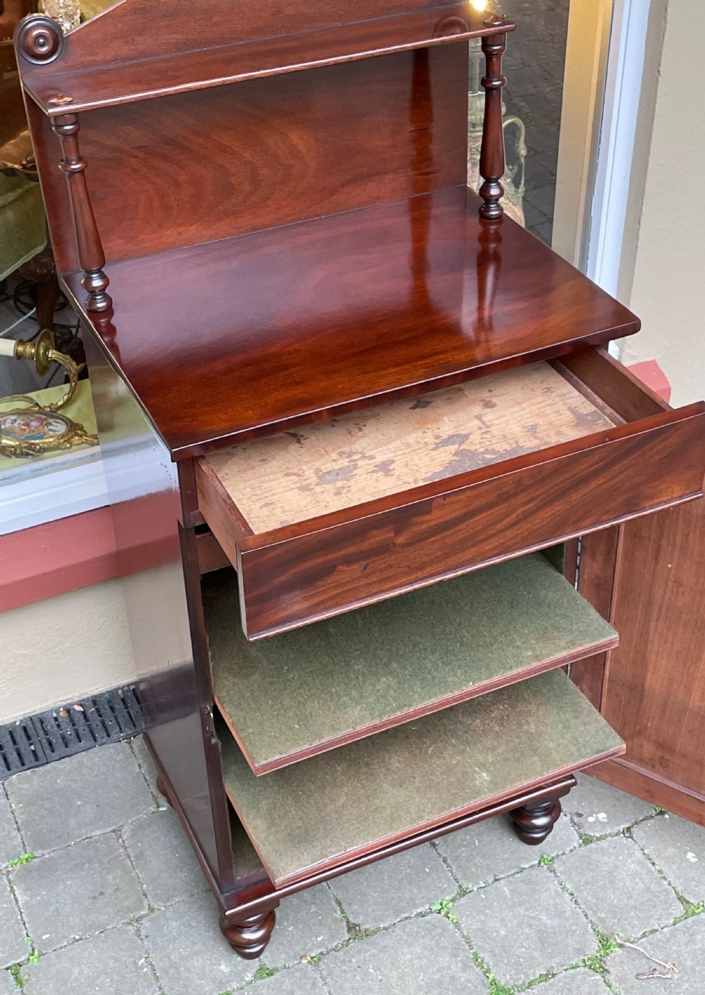 An early Victorian mahogany chiffonier sideboard featuring a top shelf with turned supports, a single frieze drawer, and a paneled cupboard door. View VIII