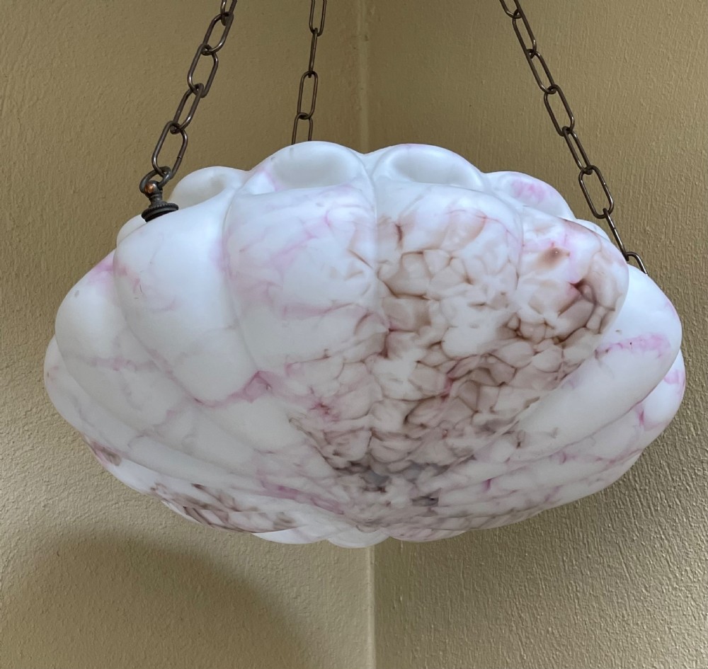 A white and pink marbled glass bowl light shade with a scalloped edge, suspended by three metal link chains. View VI
