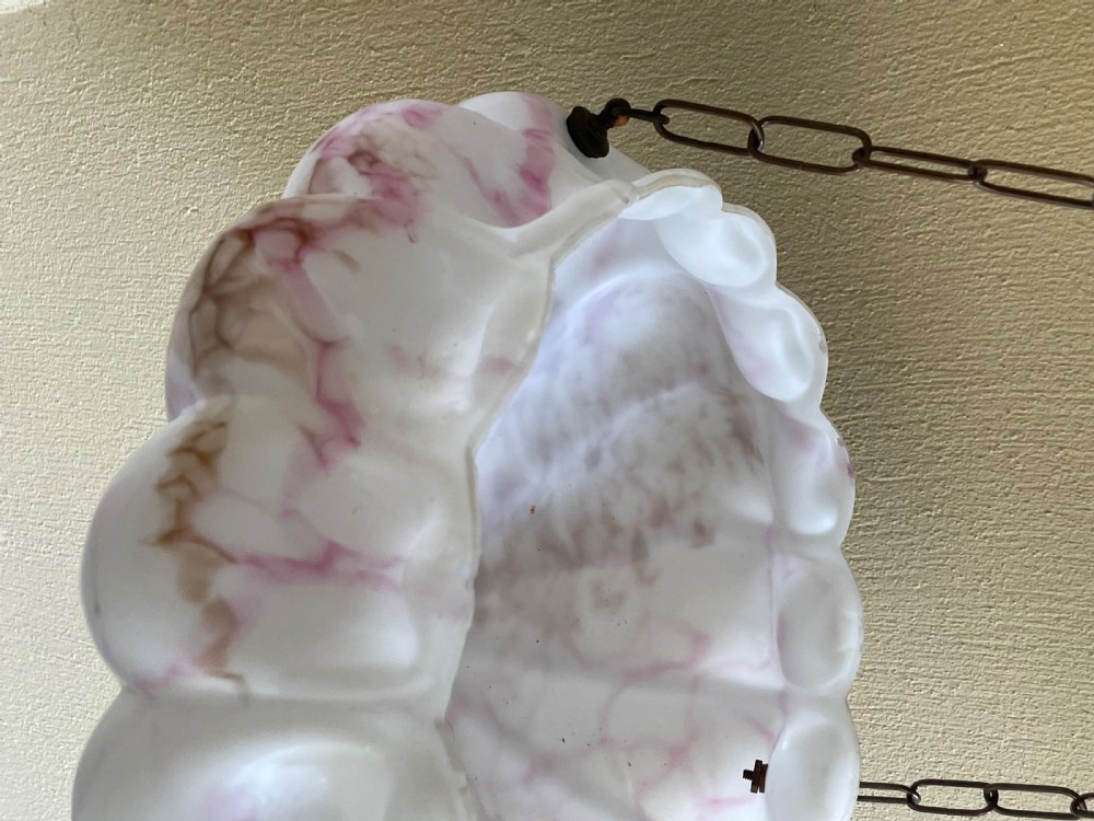 A white and pink marbled glass bowl light shade with a scalloped edge, suspended by three metal link chains. View VII