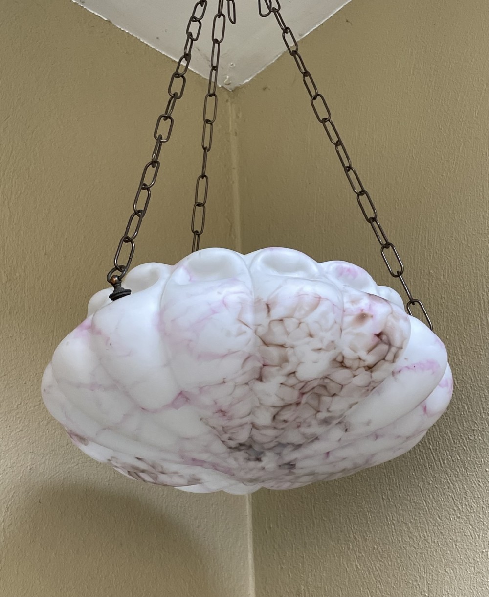 A white and pink marbled glass bowl light shade with a scalloped edge, suspended by three metal link chains. View VIII
