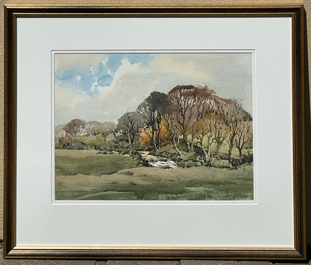 A framed original watercolour painting depicting a river flowing through a field surrounded by bare trees under a cloudy sky.