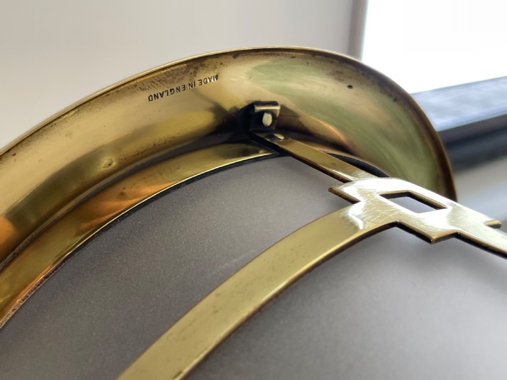 An Art Deco cylindrical hall lantern constructed with polished brass geometric framing surrounding a frosted glass shade, suspended by a brass chain. View IV