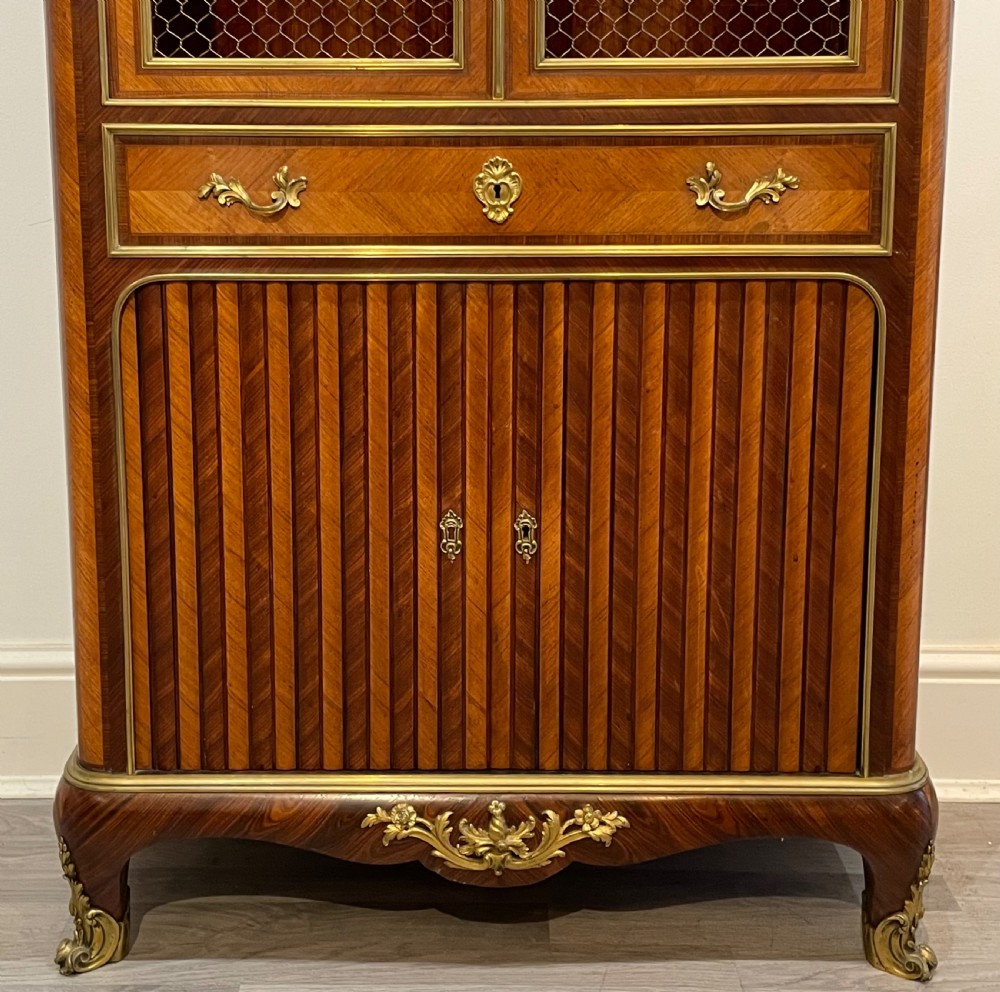 French kingwood cabinet featuring wire mesh upper doors, a marble top, gilt-bronze corner mounts, a central drawer, and reeded lower doors. View III
