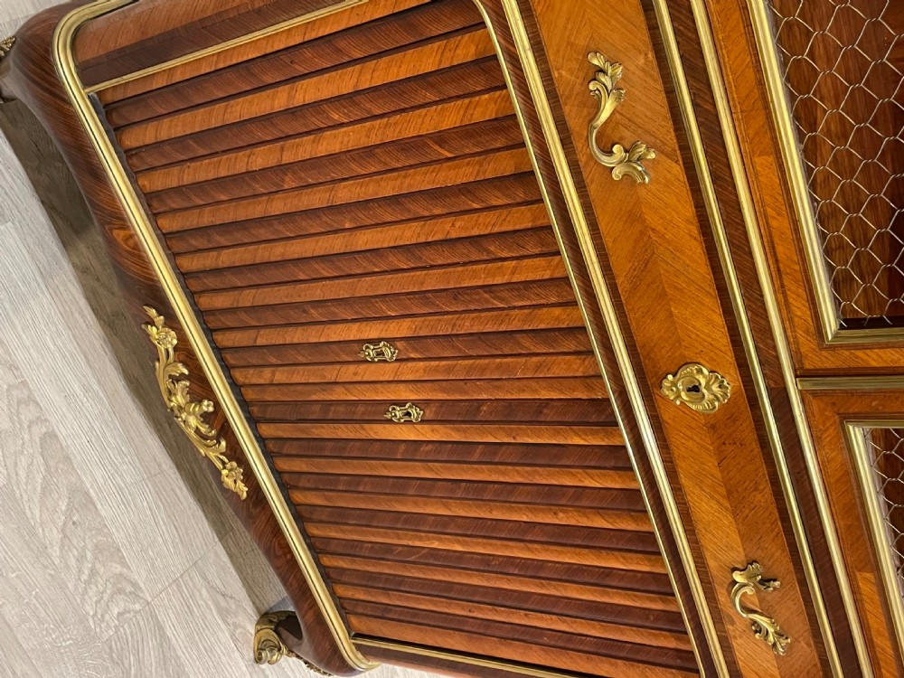 French kingwood cabinet featuring wire mesh upper doors, a marble top, gilt-bronze corner mounts, a central drawer, and reeded lower doors. View VI
