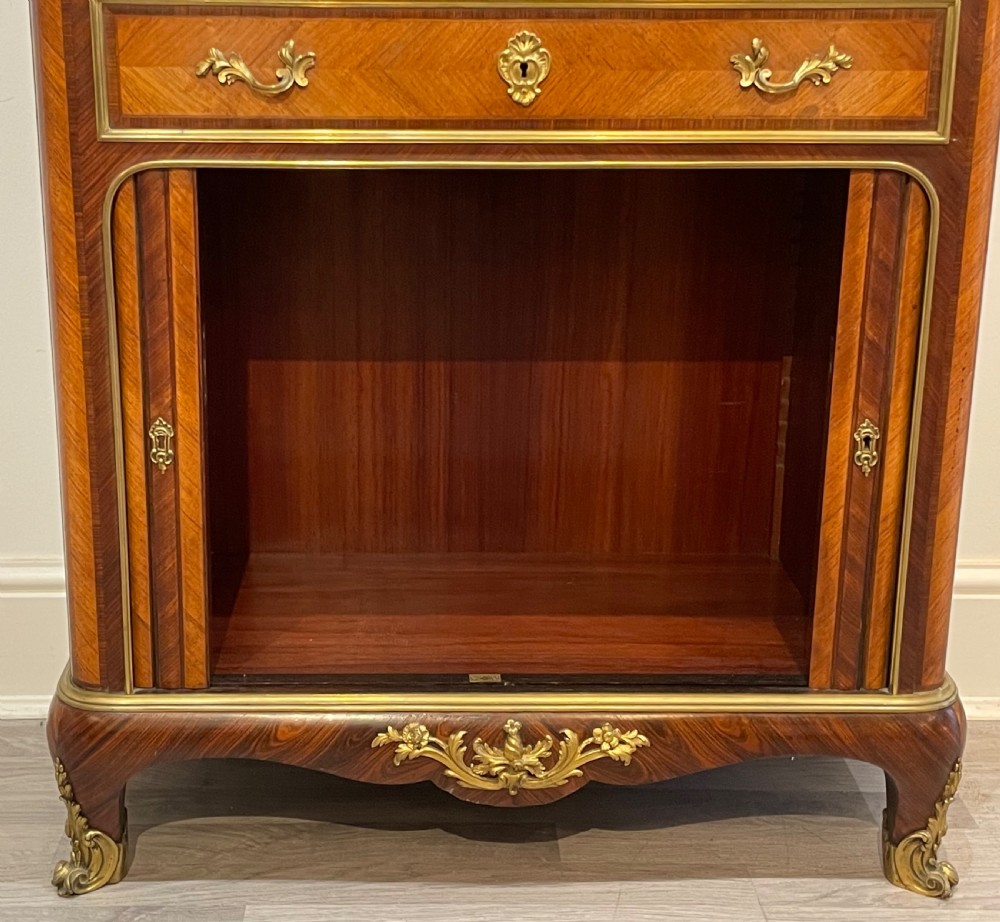 French kingwood cabinet featuring wire mesh upper doors, a marble top, gilt-bronze corner mounts, a central drawer, and reeded lower doors. View VII