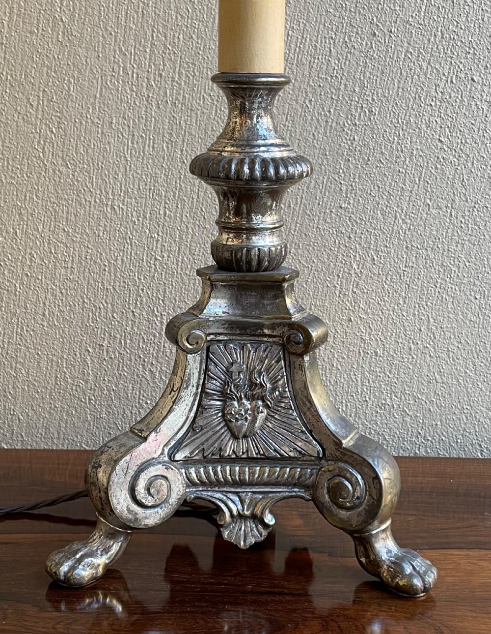 A late 19th-century French silver-plated ecclesiastical lamp base featuring a Sacred Heart motif on a triform base with paw feet and a cream faux candle sleeve. View III