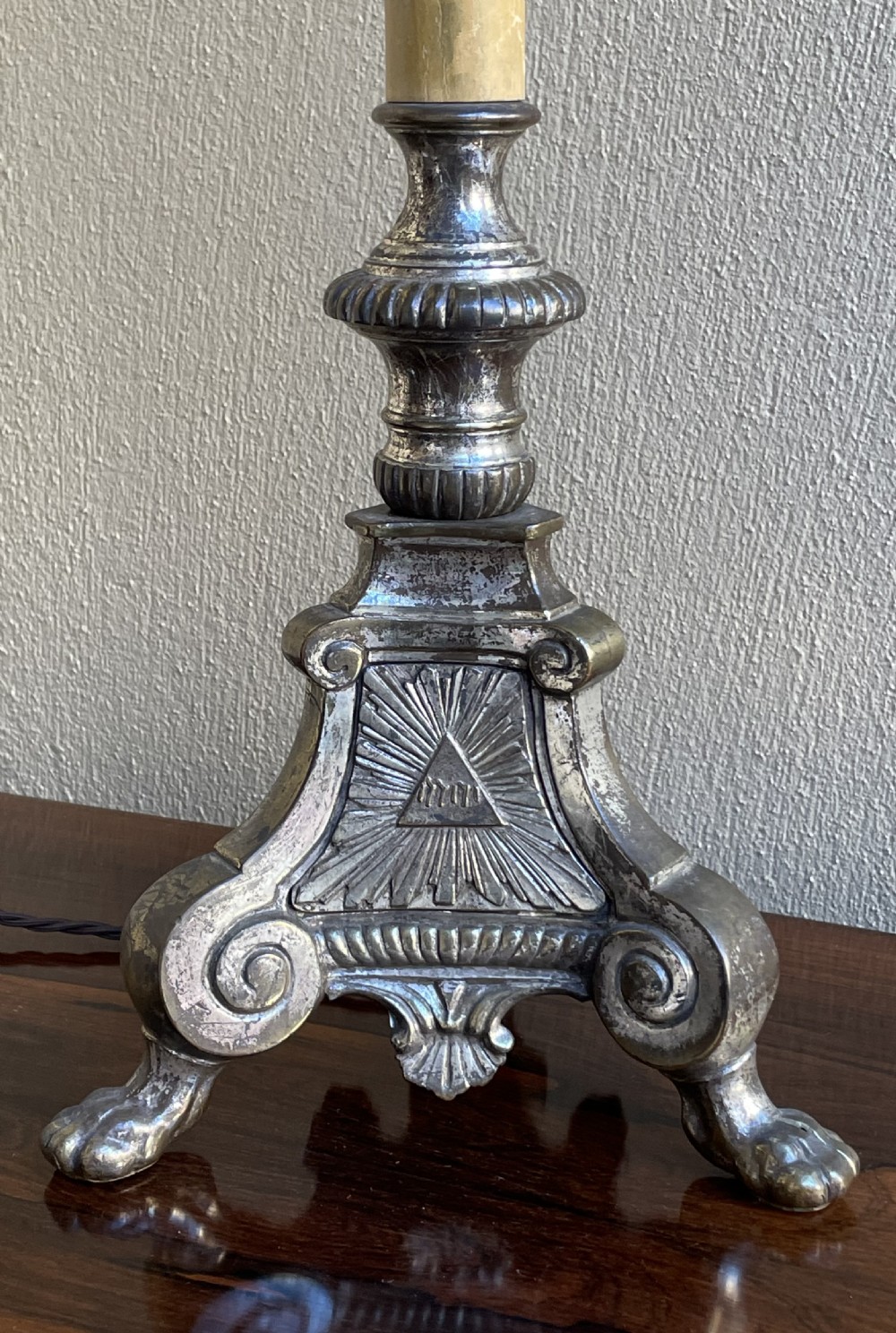 A late 19th-century French silver-plated ecclesiastical lamp base featuring a Sacred Heart motif on a triform base with paw feet and a cream faux candle sleeve. View IV