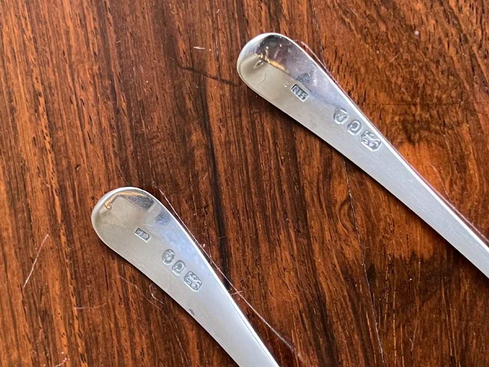 Two Georgian sterling silver sifter spoons displaying hand-pierced bowl patterns and engraved handle terminals. View II