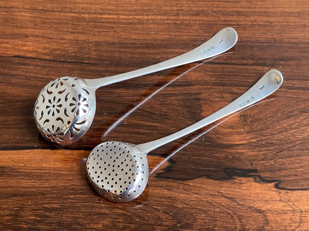 Two Georgian sterling silver sifter spoons displaying hand-pierced bowl patterns and engraved handle terminals. View III