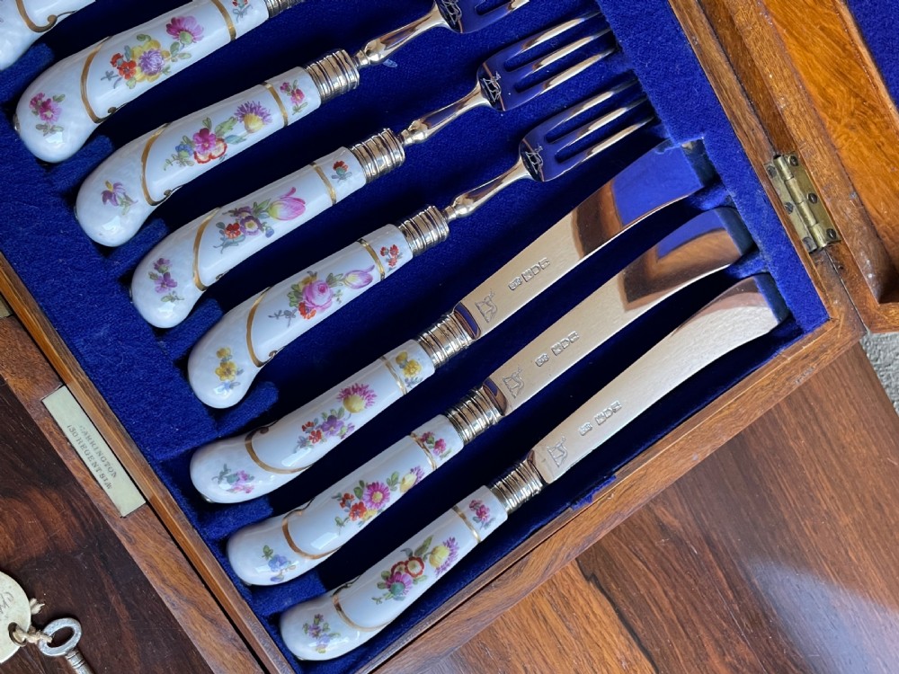 A twelve-piece silver and hand-painted porcelain dessert cutlery set housed in an open oak presentation box lined with blue velvet. View III