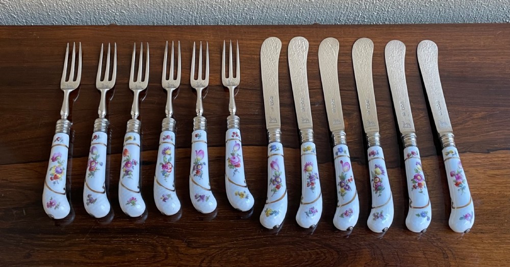 A twelve-piece silver and hand-painted porcelain dessert cutlery set housed in an open oak presentation box lined with blue velvet. View V