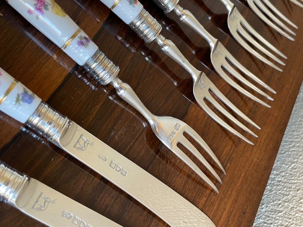 A twelve-piece silver and hand-painted porcelain dessert cutlery set housed in an open oak presentation box lined with blue velvet. View VIII