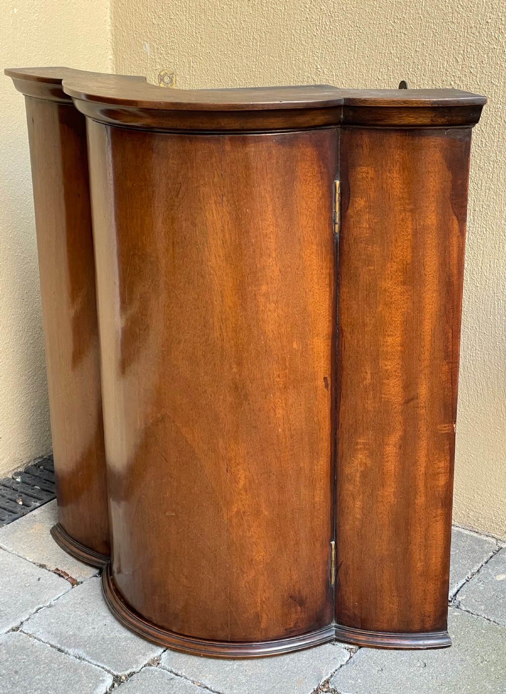 A late nineteenth-century mahogany bowfront corner cupboard with a central curved door and side panels. View II