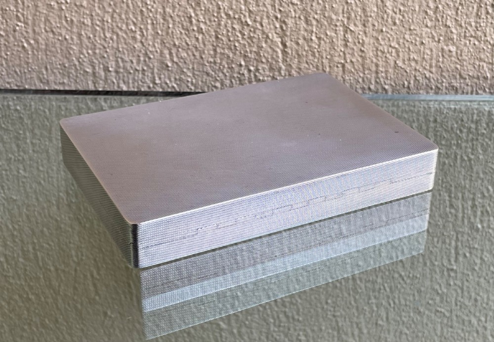 A rectangular Art Deco solid silver table box featuring fine engine-turned engraving, rounded corners, and a textured metal thumbpiece. View II