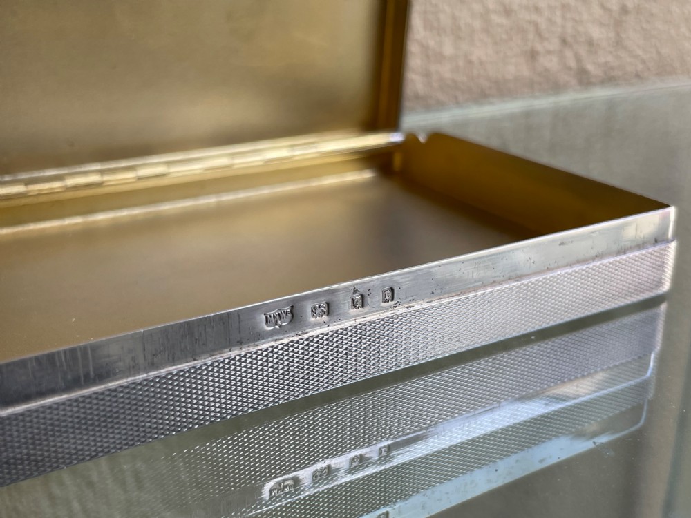 A rectangular Art Deco solid silver table box featuring fine engine-turned engraving, rounded corners, and a textured metal thumbpiece. View V