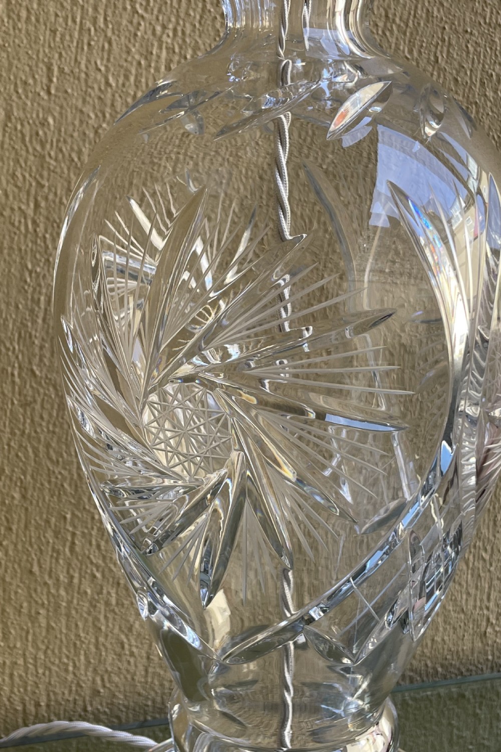 An urn-shaped clear cut crystal table lamp base with geometric starburst facets and a chrome fitting. View II