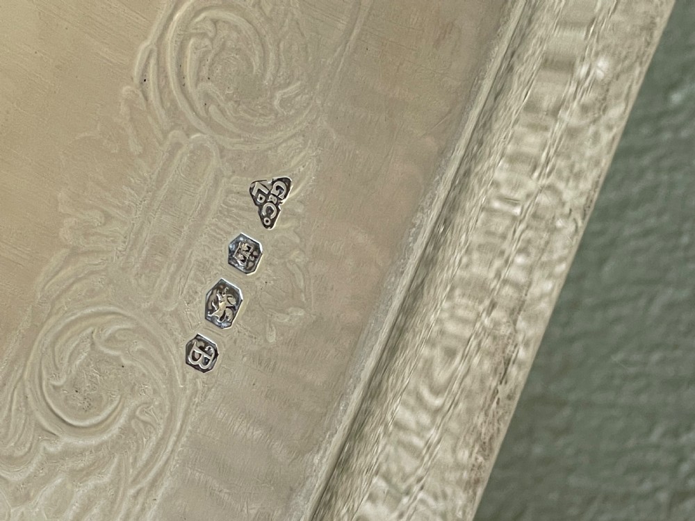 A square solid silver tray featuring hand-engraved scrollwork borders, shell corner accents, and a polished metallic surface. View IV
