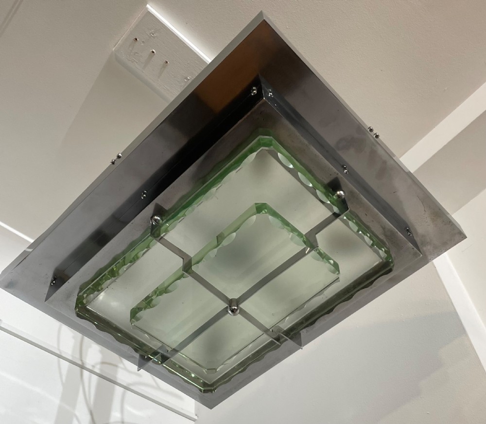 An Art Deco hanging pendant light featuring a tiered chrome-plated metal frame holding layered green glass plates suspended from a central stem. View III
