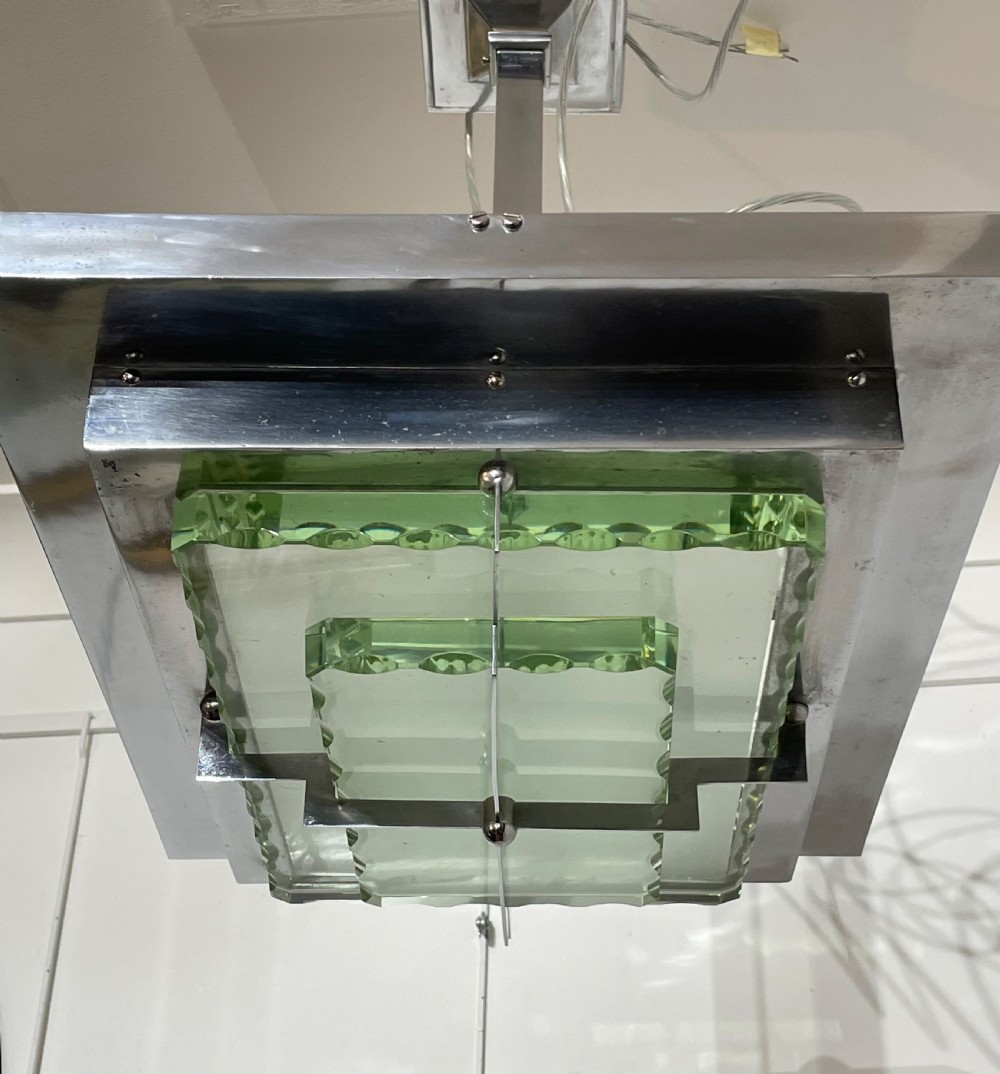 An Art Deco hanging pendant light featuring a tiered chrome-plated metal frame holding layered green glass plates suspended from a central stem. View IV