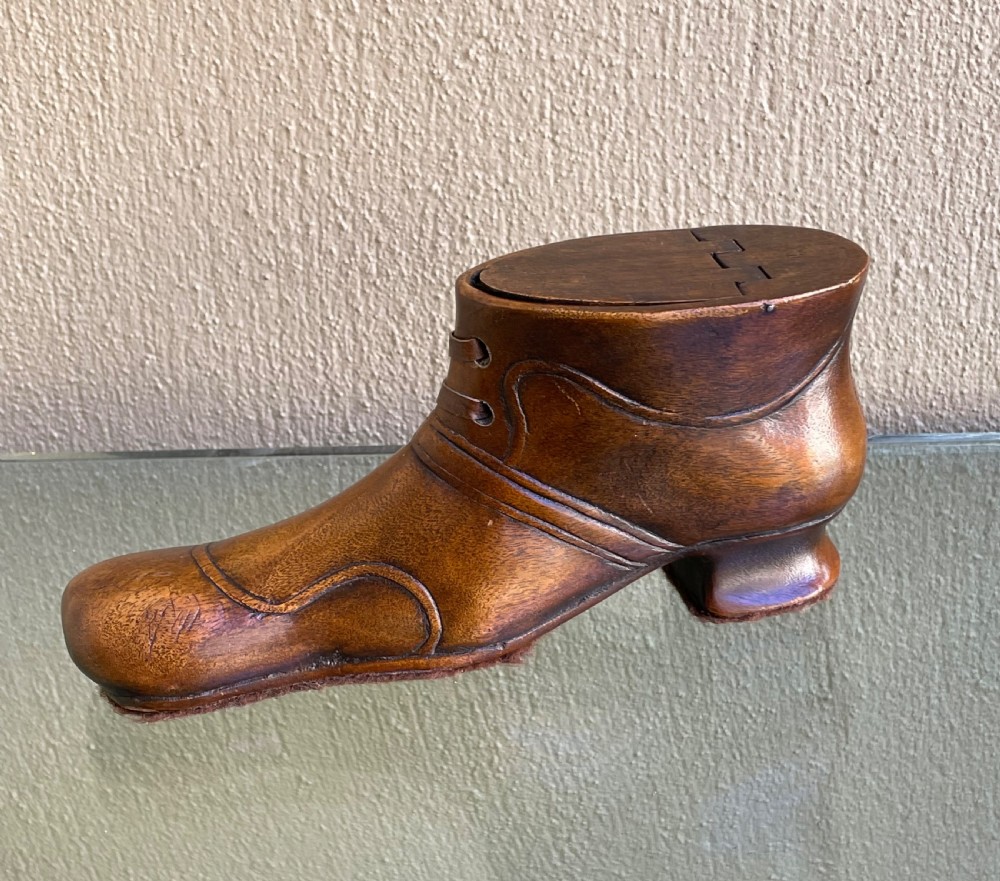 A late Victorian hand-carved wooden snuff box in the shape of a laced shoe with a sliding top lid.