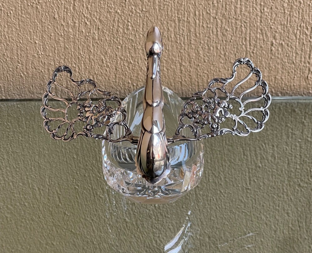 A cut glass dish featuring an ornate silver-plated swan head, neck, and articulated pierced wings. View V