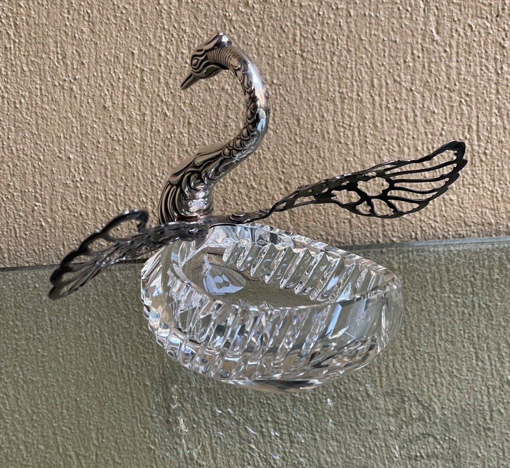 A cut glass dish featuring an ornate silver-plated swan head, neck, and articulated pierced wings. View VI
