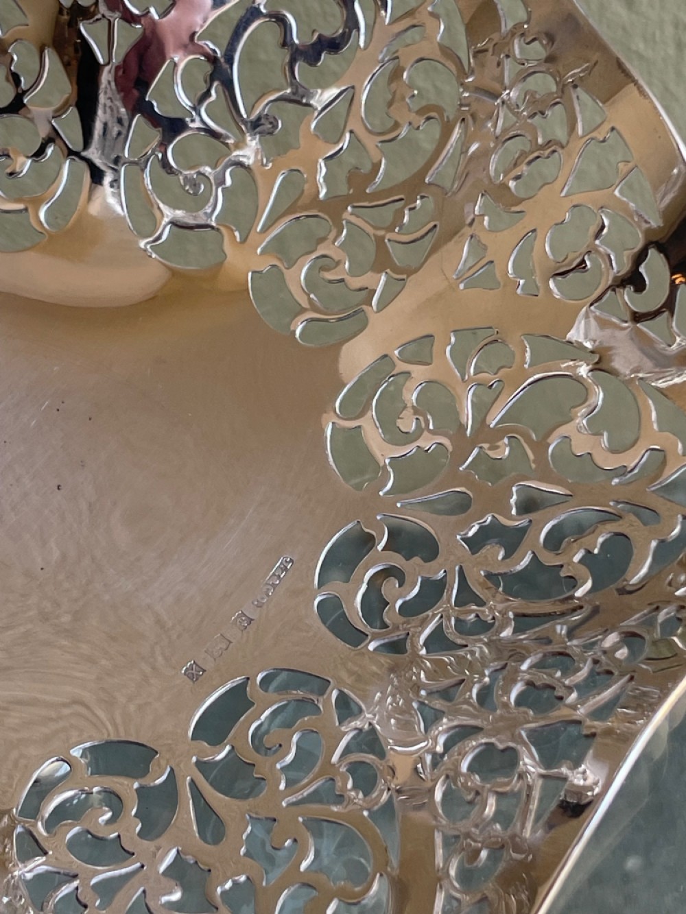 A pierced silver bonbon dish featuring a hinged overhead swing handle and intricate floral lattice openwork. View II