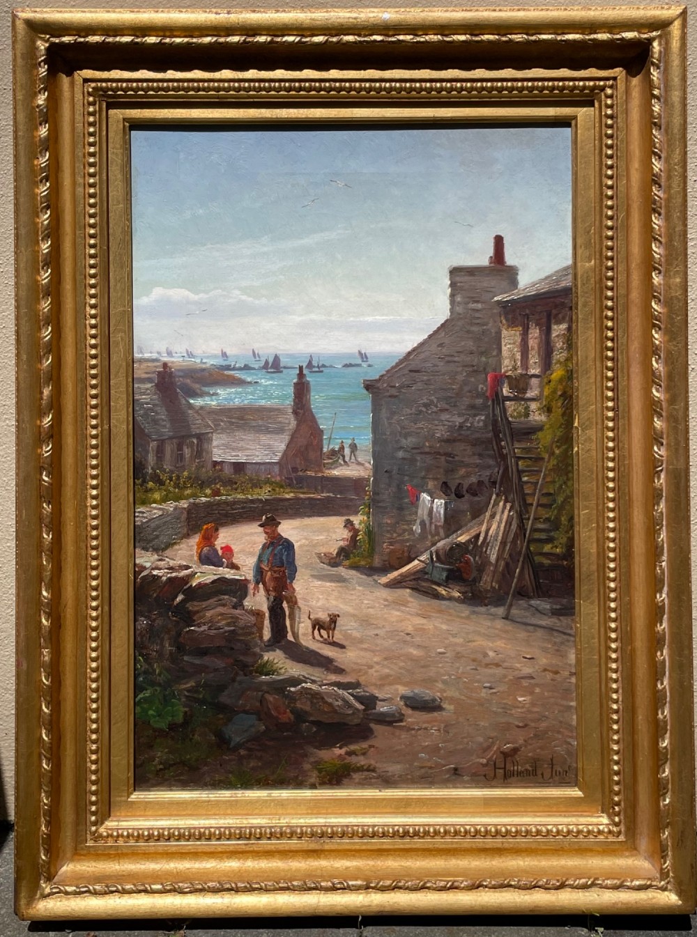 A framed 19th-century oil painting depicting a coastal village scene in Port Erin with stone cottages, figures, and fishing boats on the sea, enclosed within a gilded wooden frame.