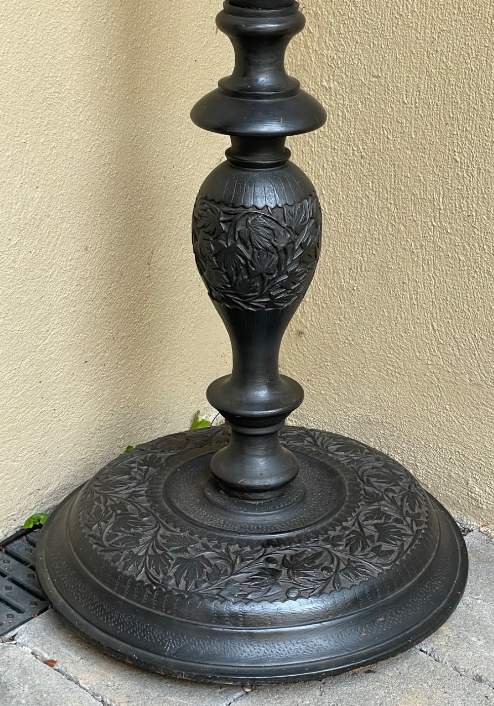 A tall Anglo-Indian hand-carved dark wood standard lamp featuring intricate foliate patterns on a turned column and circular base, topped with a brass bulb socket. View III