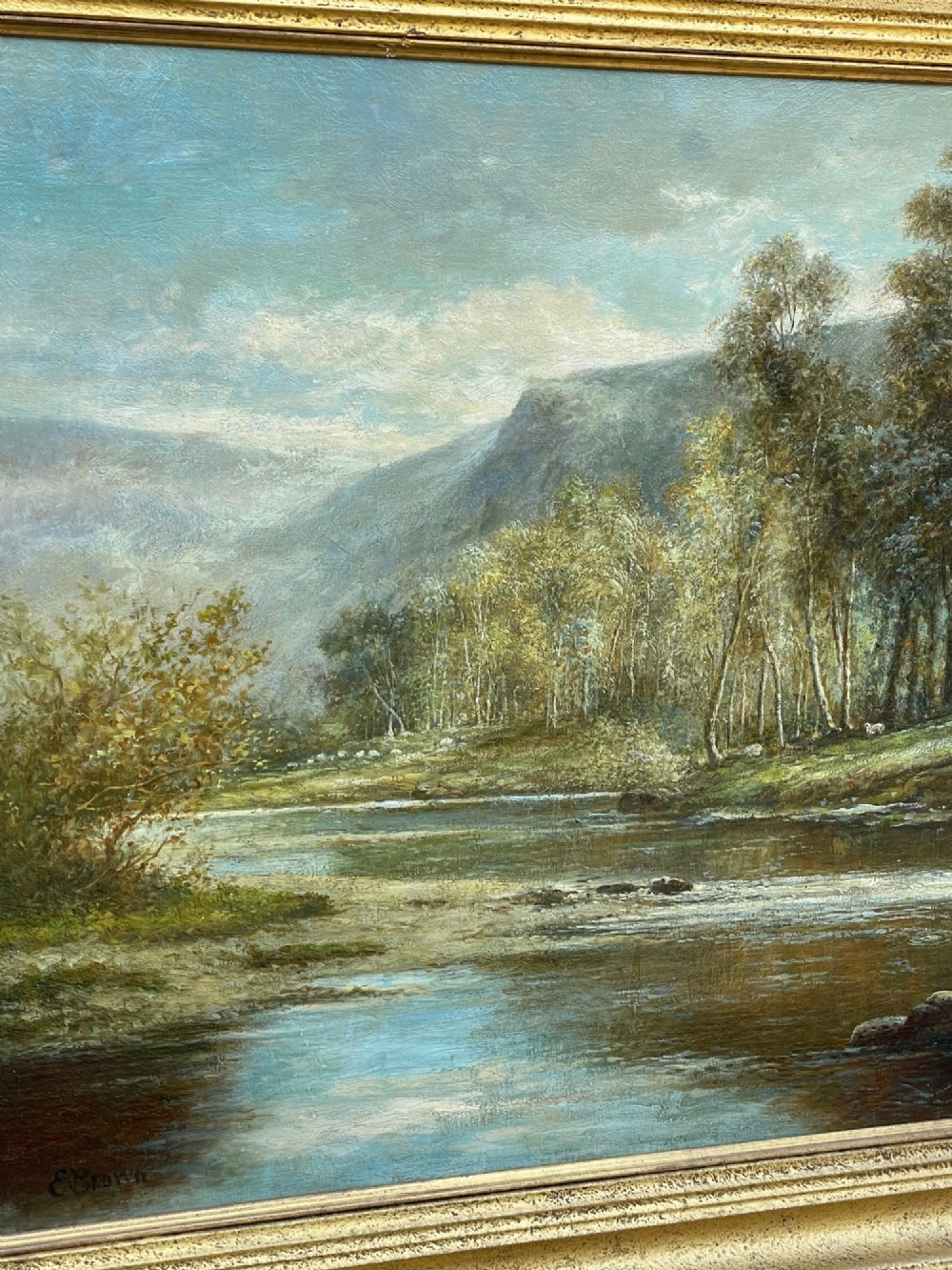 Late Victorian oil painting depicting a river scene surrounded by trees and mountains, set within a moulded gilded frame. View III