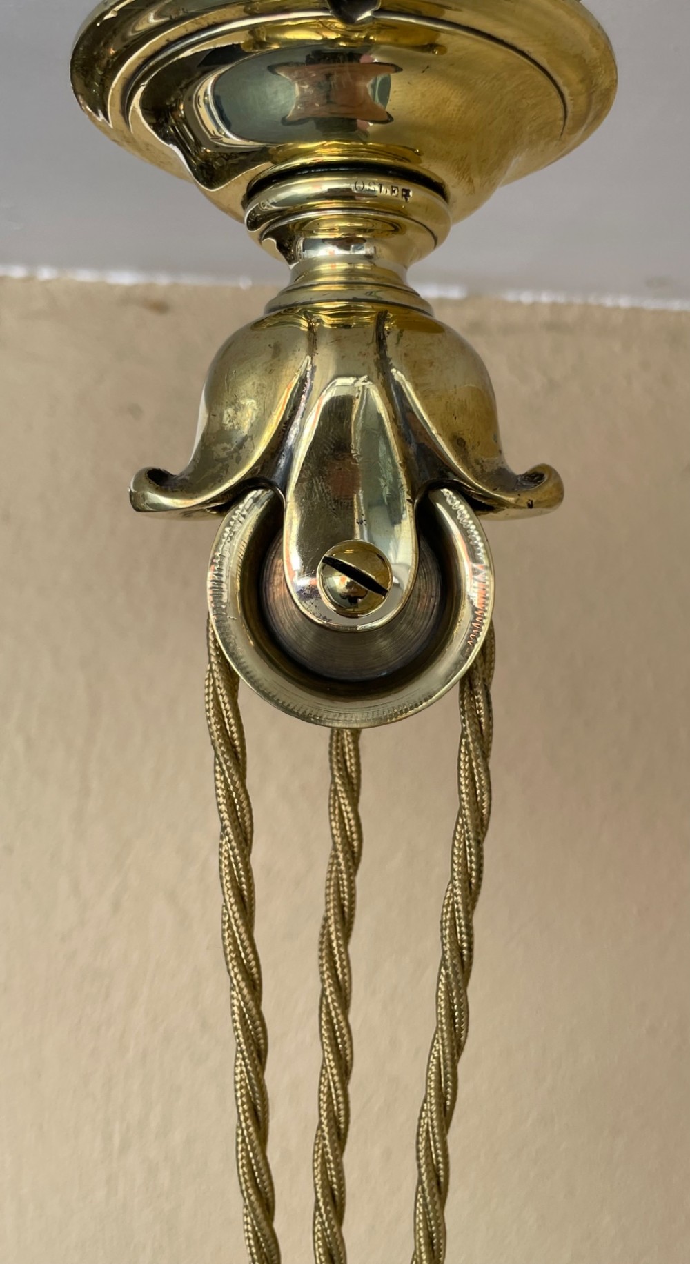 A Victorian brass rise and fall pendant light featuring a pulley mechanism, brass counterweight, twisted cord, and frosted glass shade. View V