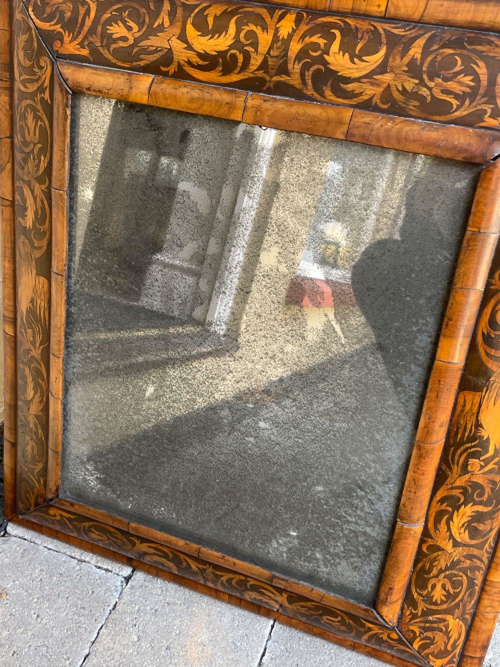 A rectangular antique William and Mary cushion-moulded wall mirror featuring intricate foliate marquetry inlay across the wooden frame and an aged glass pane. View III