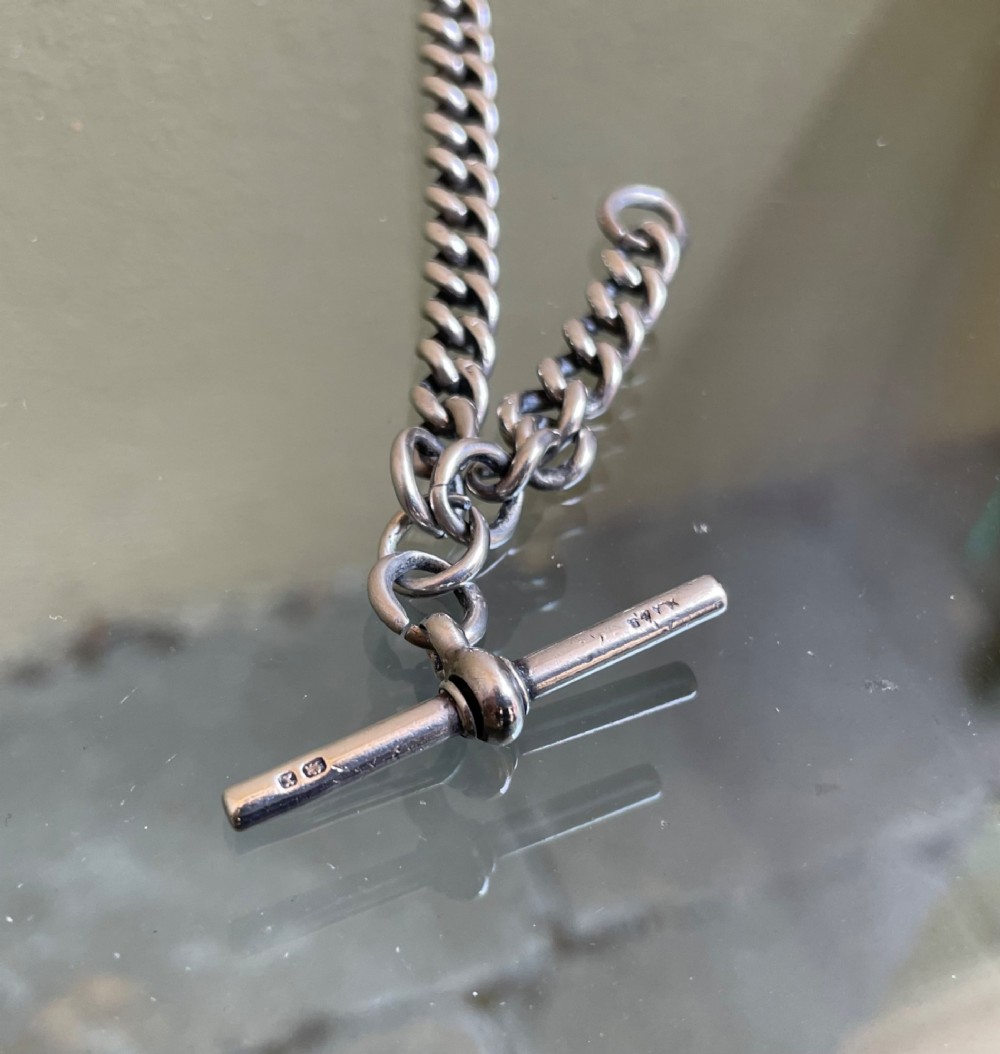 A late Victorian sterling silver single Albert chain featuring curb links, a T-bar, and a swivel clasp. View III