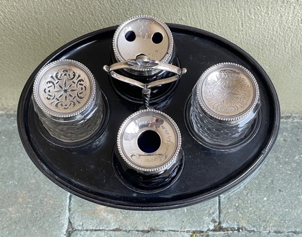 An oval ebony tray holding four diamond-cut glass pots with pierced sterling silver lids and a central silver loop handle. View III
