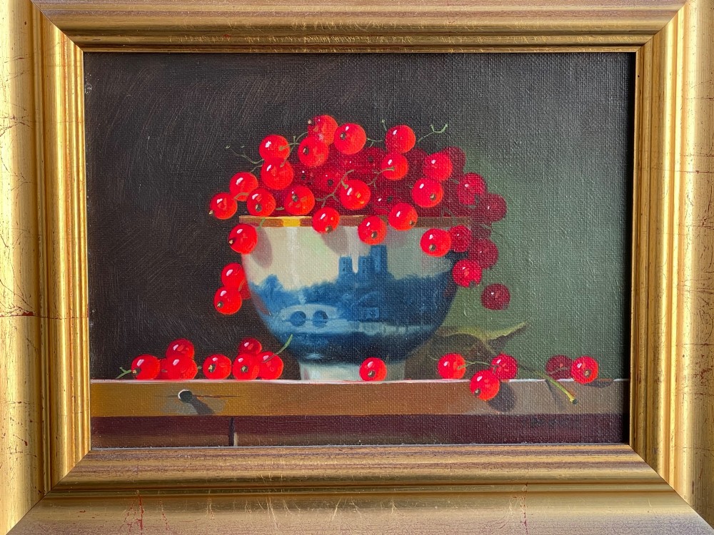 A framed oil painting depicting red berries overflowing from a blue and white porcelain bowl onto a dark wooden surface. View II