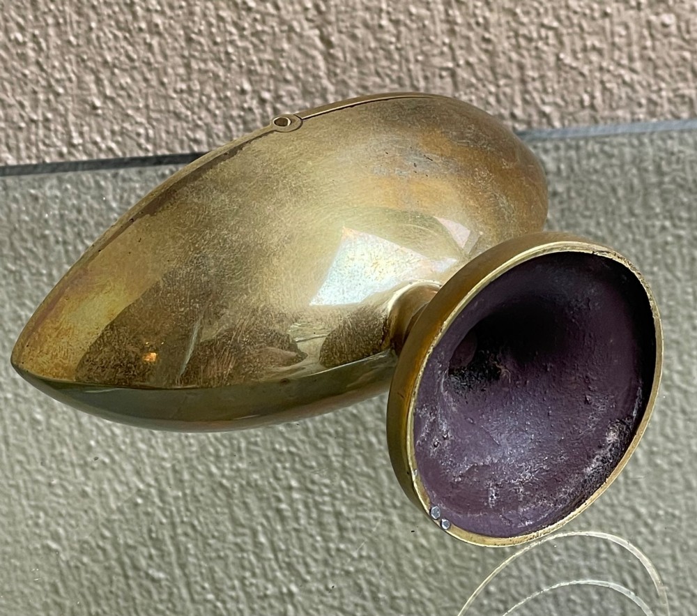 A Georgian navette-shaped brass table snuff box with a central hinged lid elevated on a circular pedestal foot. View V