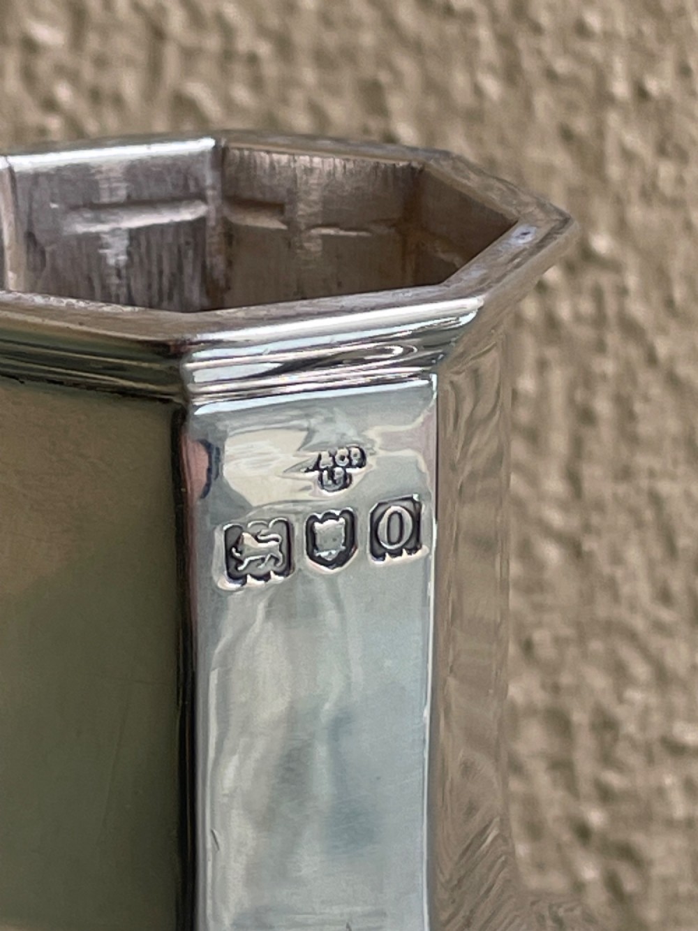 An Edwardian octagonal sterling silver sugar caster featuring a pierced domed lid topped with a finial and stamped with British hallmarks on the neck. View III