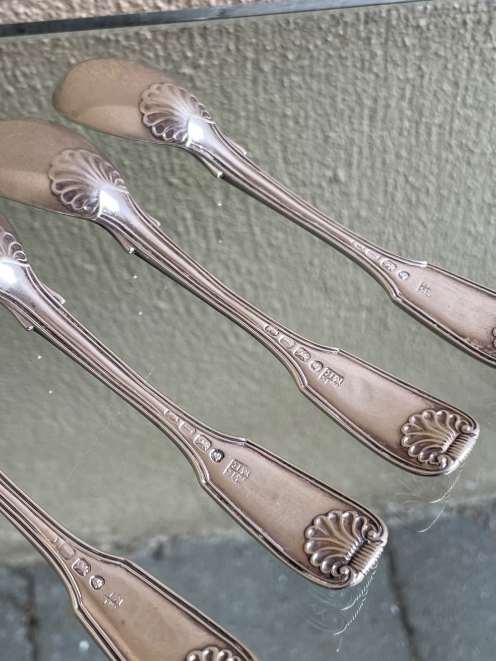 A set of five George IV sterling silver egg spoons featuring fiddle, thread, and shell pattern terminals displayed side by side. View V