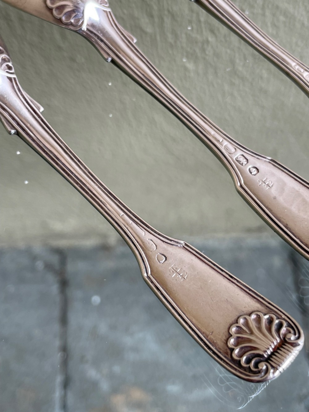 A set of five George IV sterling silver egg spoons featuring fiddle, thread, and shell pattern terminals displayed side by side. View VI