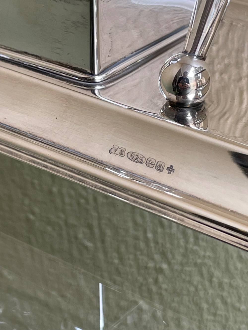 A hallmarked solid silver inkstand featuring two square cut-glass inkwells with silver lids mounted on a stepped tray with decorative feet. View V