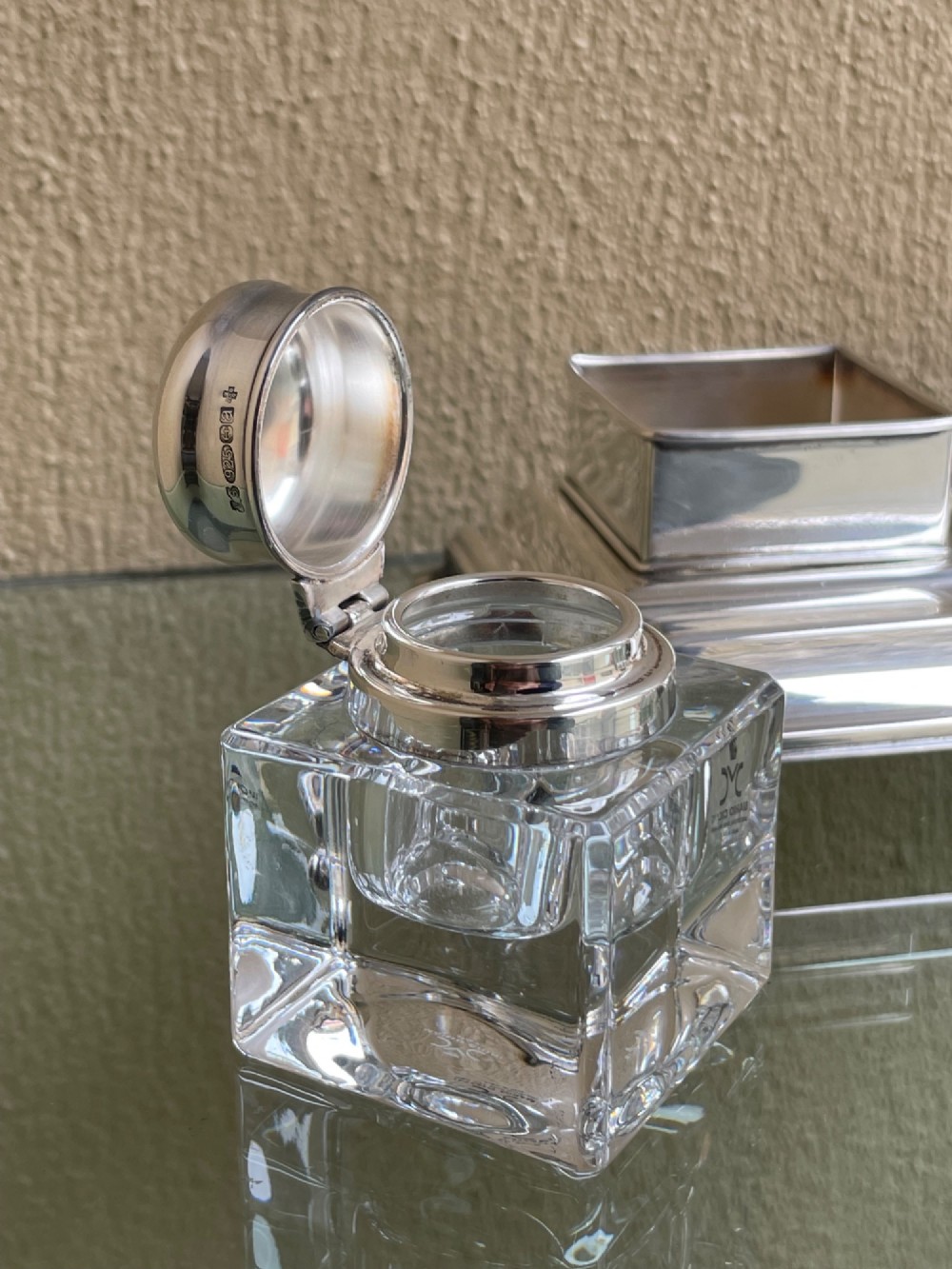 A hallmarked solid silver inkstand featuring two square cut-glass inkwells with silver lids mounted on a stepped tray with decorative feet. View VII