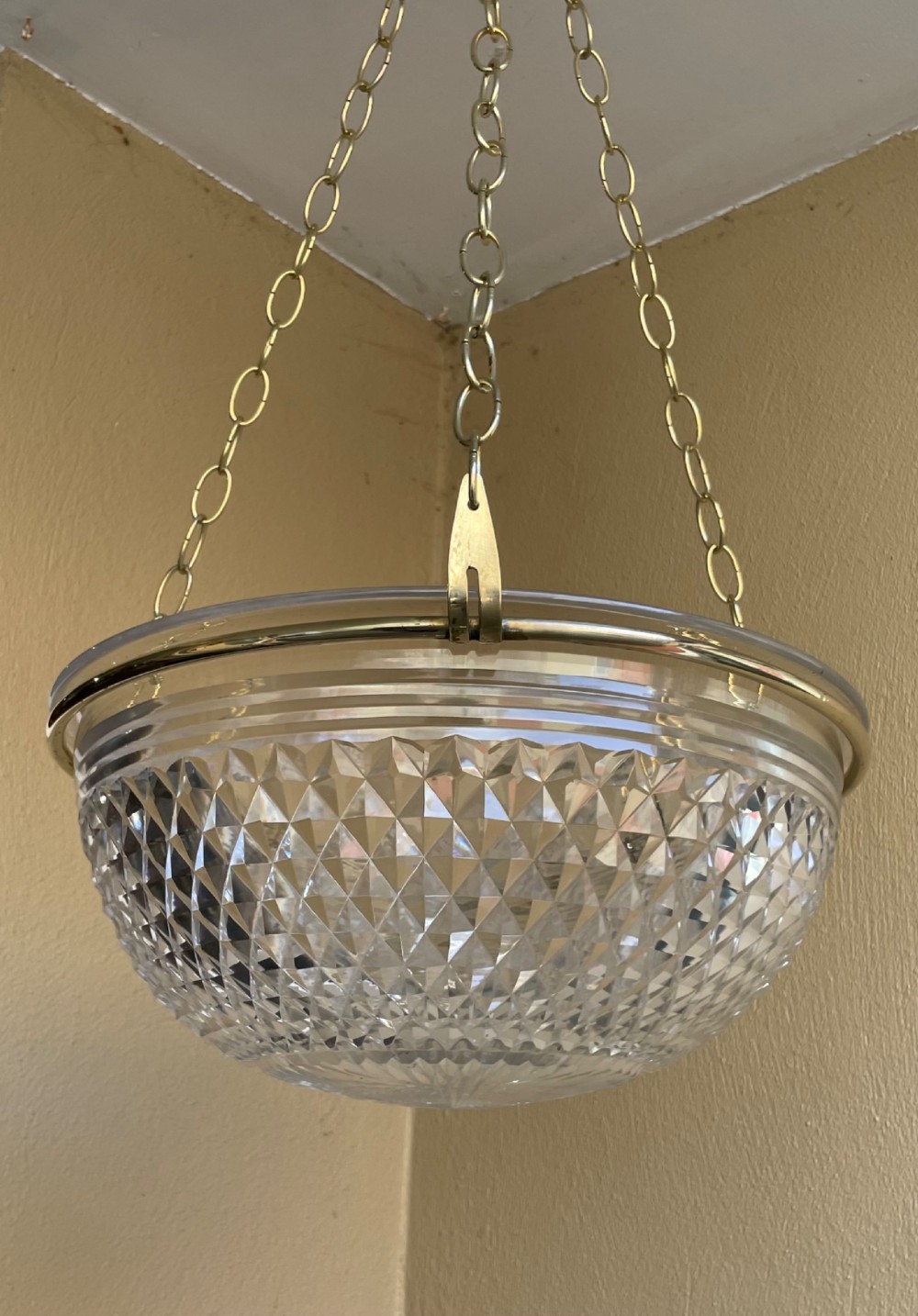 An Edwardian period cut glass bowl light shade suspended by three brass link chains connected to a central brass rim. View II