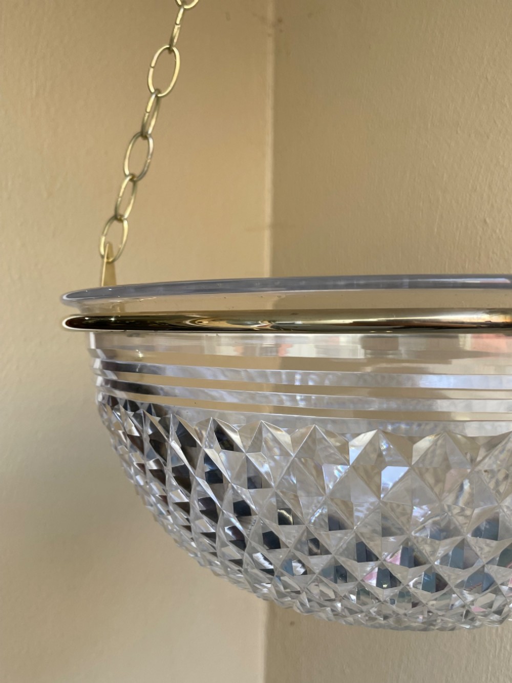 An Edwardian period cut glass bowl light shade suspended by three brass link chains connected to a central brass rim. View III